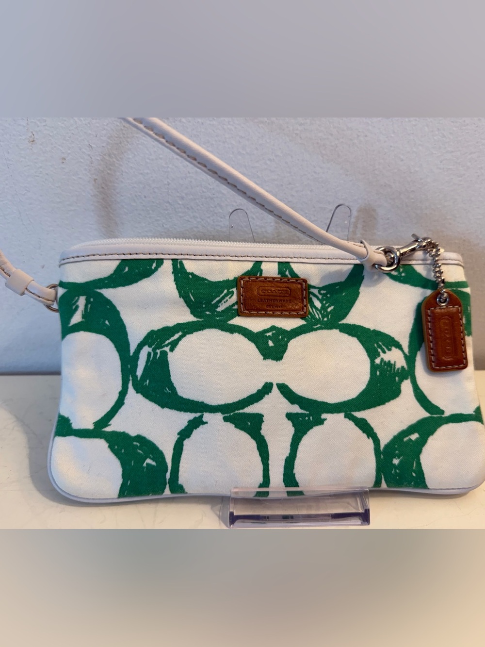Coach Hampton top handle pouch with green scribble monogram pattern.